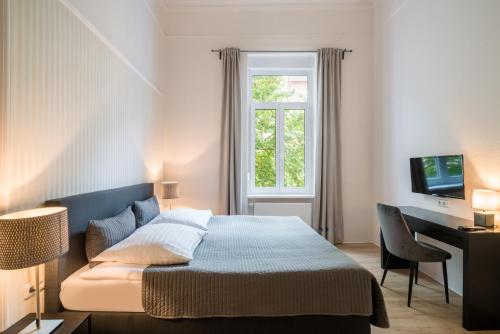 - une chambre avec un lit, un bureau et une fenêtre dans l'établissement Hotel Aurora, à Wiesbaden