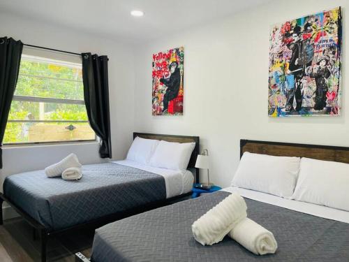 sypialnia z 2 łóżkami i oknem w obiekcie Casa Wynwood 4BR 2BTH w Miami