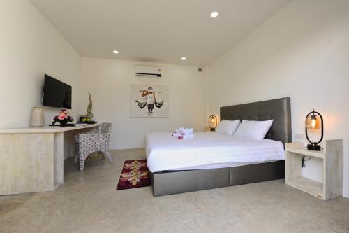 1 dormitorio con 1 cama blanca grande y escritorio en Barong Resort, en Ban Phe