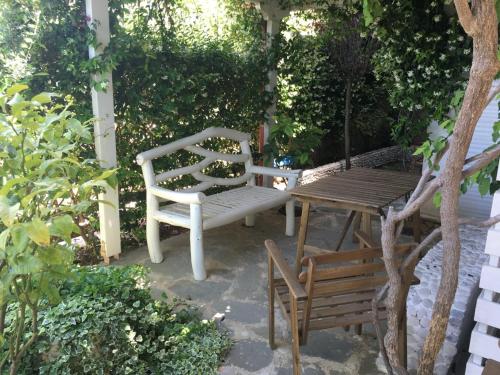 une terrasse avec deux bancs et une table en bois dans l'établissement Olives Residence, à Dhërmi