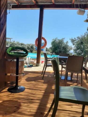 une terrasse avec une table, des chaises et une piscine dans l'établissement Olives Residence, à Dhërmi