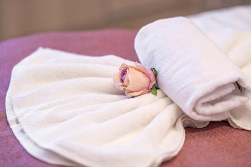 a rose in a towel on a bed at Spa Residence Carbona Apartment 105 in Hévíz