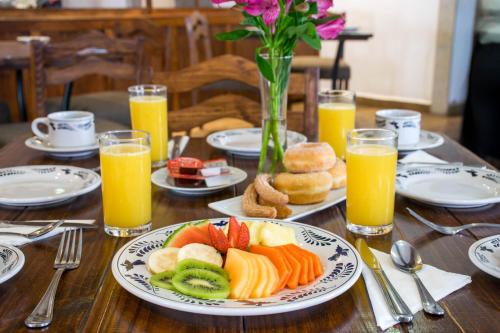 een houten tafel met een schaal fruit en sinaasappelsap bij Hotel La Casona 30 in San Miguel de Allende