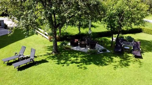 une vue sur un parc avec des bancs et un arbre dans l'établissement Gästehaus Kloibergütl, à Sankt Gilgen