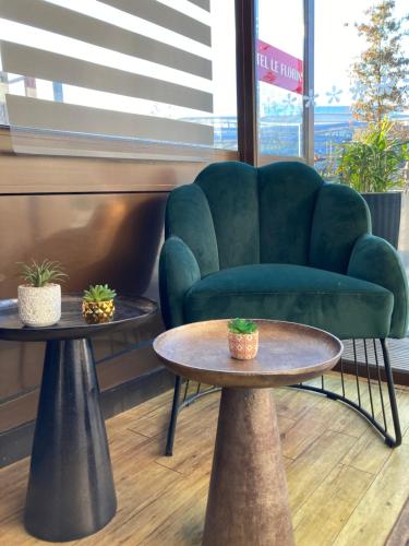 a living room with two tables and a couch at Hôtel Le Florin in Rennes