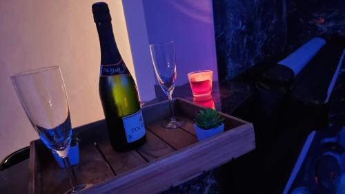 een fles wijn en twee glazen op een tafel bij RoyalSpa appartement d'amour avec jacuzzi privatif in Straatsburg