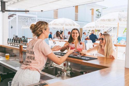 un gruppo di donne sedute in un bar con bicchieri da vino di Bounce Noosa a Noosaville