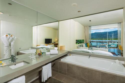 La salle de bains est pourvue d'une grande baignoire et d'un grand miroir. dans l'établissement Shangri-La The Marina, Cairns, à Cairns