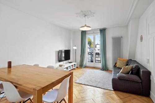 een woonkamer met een tafel en een bank bij Central Bright & Cozy Apartments in Luzern