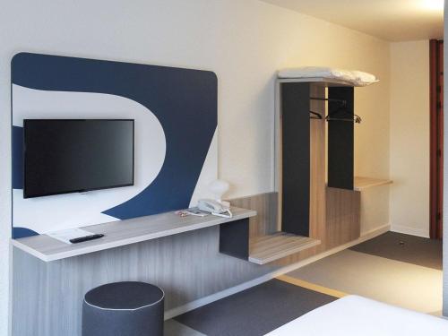 Pokój z telewizorem na ścianie w obiekcie ibis Styles Beauvais w Beauvais