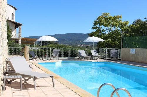 ein Pool mit Stühlen und Sonnenschirmen auf einem Gebäude in der Unterkunft Hôtel de Vacances de la Vignasse in Chandolas