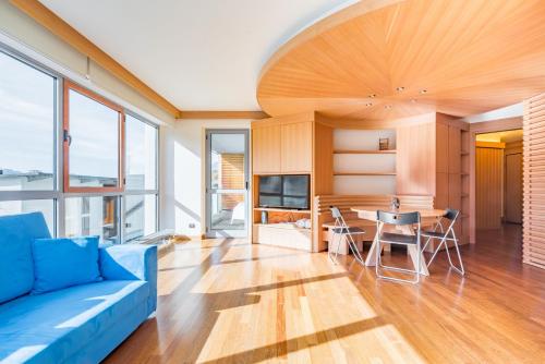 a living room with a blue couch and a table at Terrazza su Sestriere Lux in Sestriere