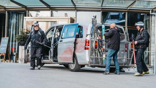 Un gruppo di persone in piedi accanto a un furgone con gli sci sopra. di Peaks Place Apartments & SPA a Laax