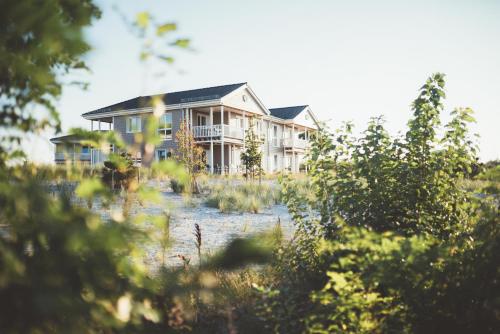 ein Haus, das durch die Bäume gesehen wird in der Unterkunft Beach Apartments Heiligenhafen in Heiligenhafen