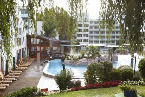 a swimming pool in a city with a building at Spa Residence Carbona Royal Suites 1.11 in Hévíz