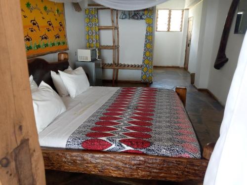 una camera da letto con un letto con un tappeto sopra di Ziwa Beach Resort a Bamburi