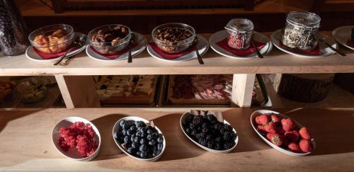 ein Regal mit Schalen mit Desserts und Schalen mit Beeren in der Unterkunft Hotel Galli in Livigno