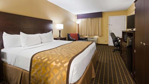 een hotelkamer met een groot bed en een bureau bij Best Western Green Tree Inn in Clarksville