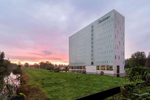 uma representação de um edifício com um campo à sua frente em Radisson Hotel & Suites Amsterdam South em Amstelveen