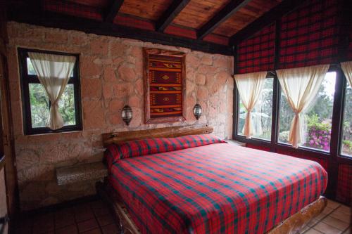 a bedroom with a bed in a room with windows at Monteverde in Mazamitla