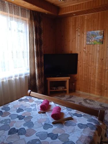 1 dormitorio con 1 cama con 2 toallas rosas en Карпатські ночі, en Yaremche