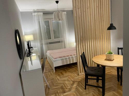 een kleine kamer met een tafel en een bed bij Apartmani Sombor in Sombor