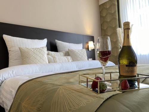 een fles wijn en een glas op een bed bij REGIOHOTEL Naturresort Ilsenburg in Ilsenburg