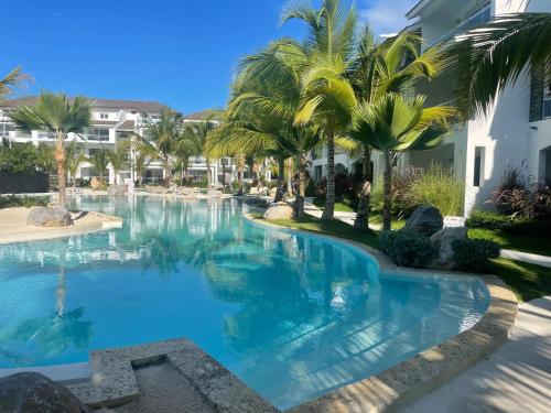 uma piscina com palmeiras num resort em Atmospheric apartment with a beautiful view of the swimming pool em Bayahibe