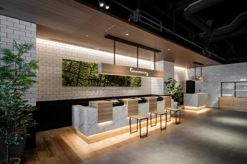 a lobby with a bar with stools at Tokyu Stay Shinjuku Eastside in Tokyo