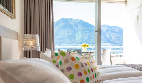 um quarto com uma janela com vista para uma montanha em Smart-HOTEL MINUSIO, a Benvenuti Hotel em Locarno