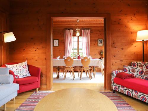 sala de estar con sillas rojas y mesa en Chalet Chalet Merymont by Interhome, en Villars-sur-Ollon