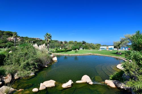 un estanque en un parque con rocas en el agua en Bagaglino I Giardini Di Porto Cervo, en Porto Cervo