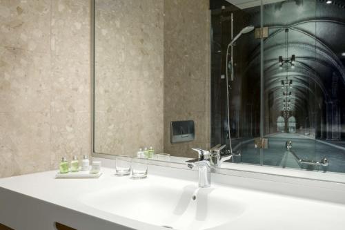 a bathroom with a sink and a mirror at NH Bussum Jan Tabak in Bussum