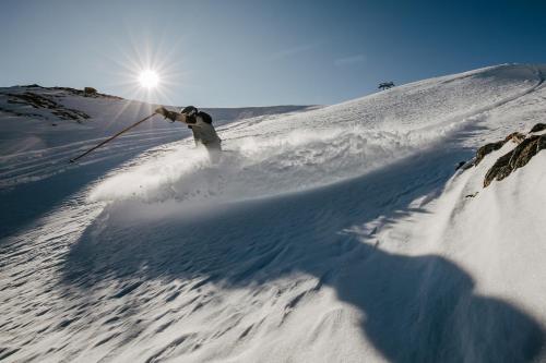 een persoon is aan het skiën op een sneeuw bedekte helling bij Boutique Hotel Martha in Zell am See