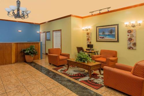 una sala de espera con sillas naranjas y una mesa en Days Inn by Wyndham Fort Myers, en Fort Myers