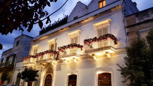 um edifício branco com flores nas varandas em Palazzo Scotto em Alberobello