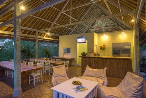 ein Restaurant mit einem Tisch und Stühlen sowie einer Bar in der Unterkunft Komodo Garden in Nusa Lembongan