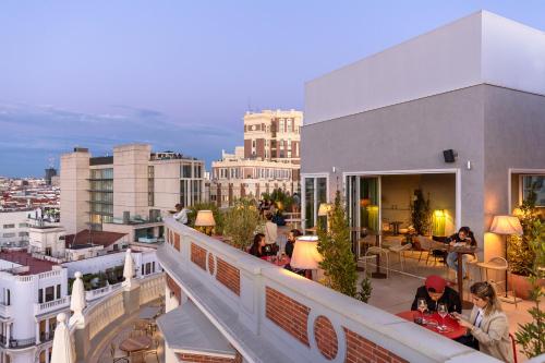 a group of people sitting on the balcony of a building at Room Mate Macarena – Gran Vía in Madrid