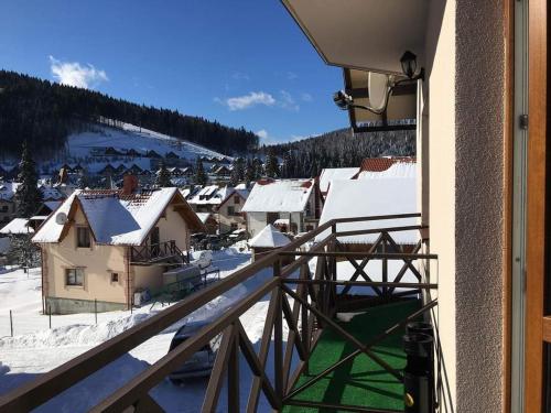 una vista da un balcone di un villaggio con neve di Guest House Mountain a Bukovel