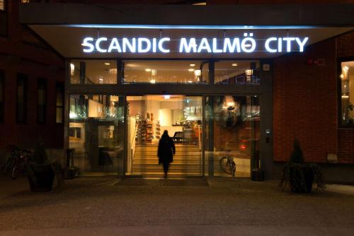 Eine Person, die nachts aus der Änna Mallimo-Stadt geht in der Unterkunft Scandic Malmö City in Malmö