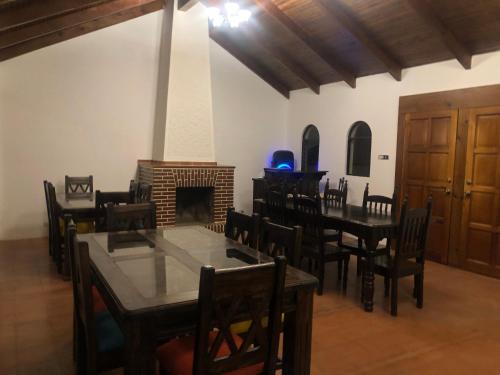 une salle à manger avec des tables, des chaises et une cheminée dans l'établissement Hotel Mansion Del Rey, à Antigua Guatemala