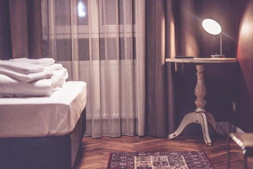 a bedroom with a bed and a table with a lamp at Hotel Luis in Regensburg