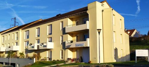 een geel gebouw met witte balkons op een heuvel bij Résidence Carouge Appart Hôtel in Brétigny-sur-Orge