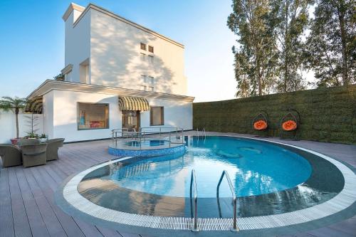 einen Pool in der Mitte einer Terrasse in der Unterkunft Country Inn & Suites by Radisson Chandigarh Zirakpur in Chandīgarh