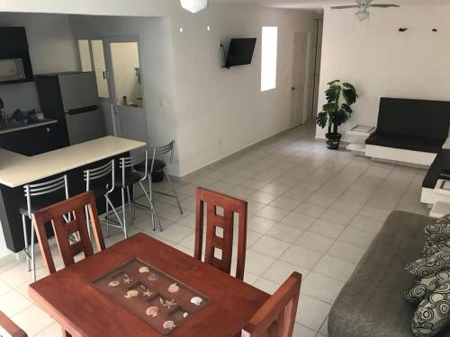 uma cozinha e sala de estar com mesa e cadeiras em Marina Diamante Acapulco con todos los Servicios em Acapulco