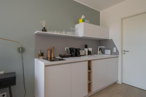 cocina con armarios blancos y encimera en limehome Flensburg Holm, en Flensburg