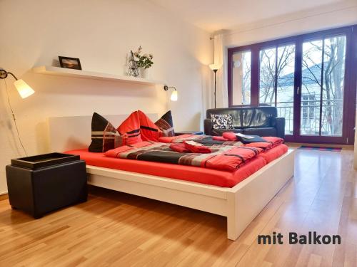 uma cama num quarto com um cobertor vermelho em FeWo 2,4,5,6 Altstadt - Am grossen Garten em Dresden