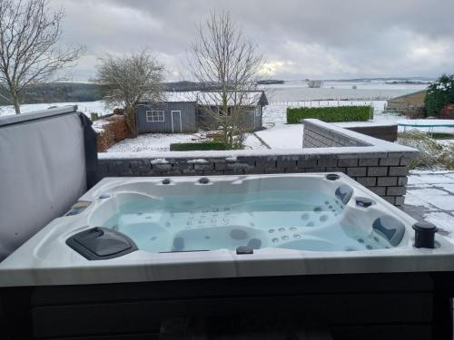 a jacuzzi tub on the back of a house at Bonheur à la campagne in Bastogne