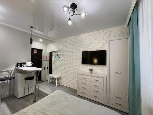 a living room with a tv on a white brick wall at Tiffany Apartment in Irpin'