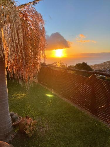 een uitzicht op de zonsondergang vanuit de achtertuin van een huis bij Casa dos Avos in Calheta